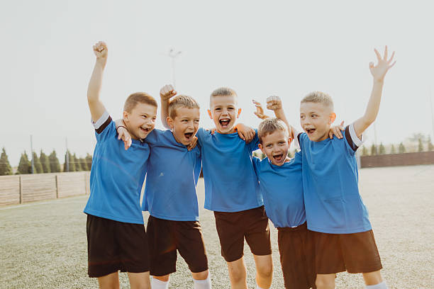 istock Junior soccer team posing together on the field in blue uniforms 2231605161