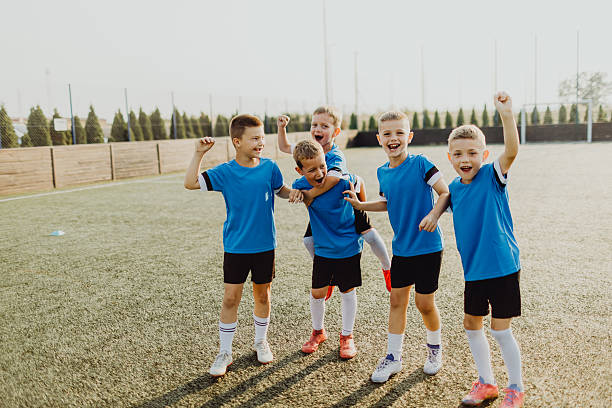 istock Junior soccer team posing together on the field in blue uniforms 2231605323