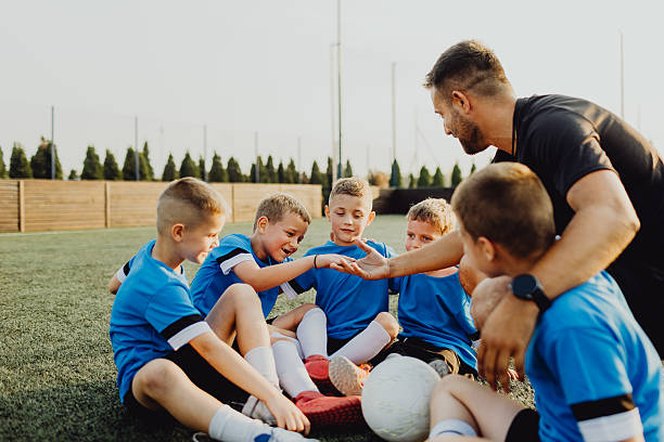 istock Coach instructing junior football team 2231605642