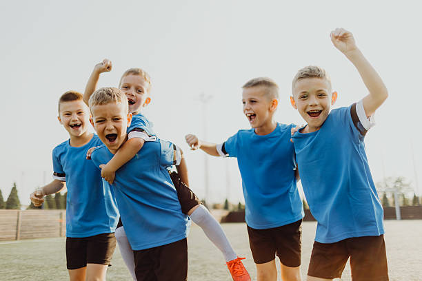 istock Junior soccer team posing together on the field in blue uniforms 2231605762