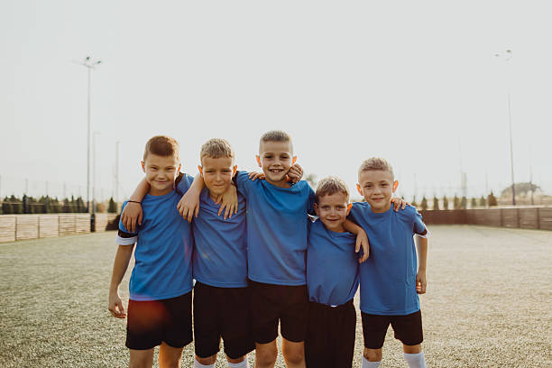 istock Junior soccer team posing together on the field in blue uniforms 2231605932