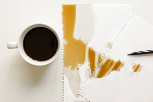 Black coffee spilled into papers and desk