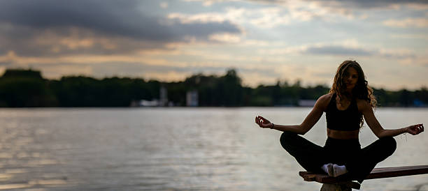 A tranquil moment of meditation by a serene lake at sunset, fostering inner peace and rejuvenating the spirit