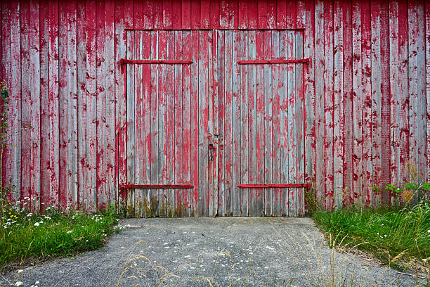 Artistic old wooden planks gate texture with peeled brown and blue paint layers under sun-bleached blue paint layer. Full-frame flat background and texture.