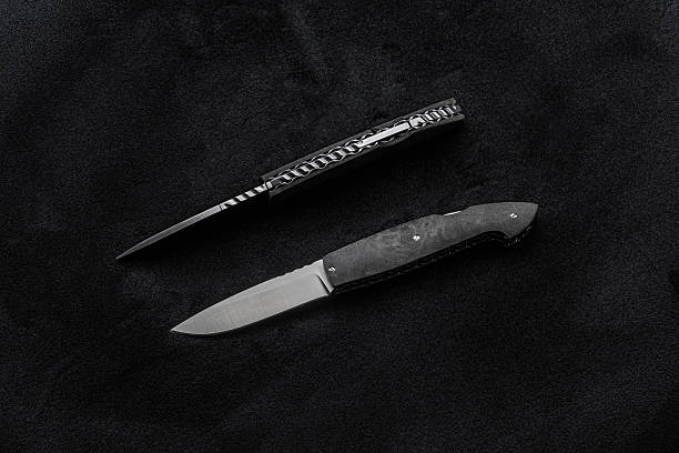 istock Two handmade folding knives, one open and one closed, on a dark fabric. 2231611223