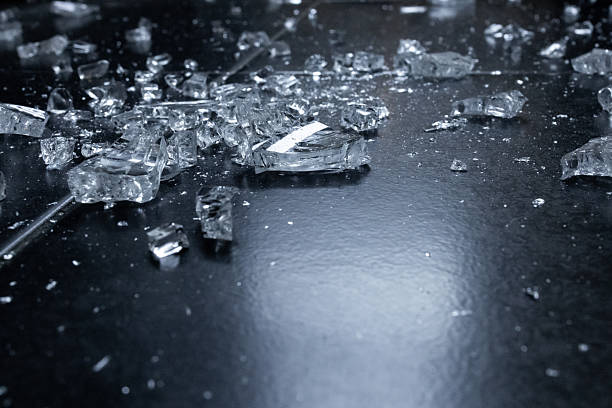 istock Shattered glass pieces on dark surface with reflective light 2231617298