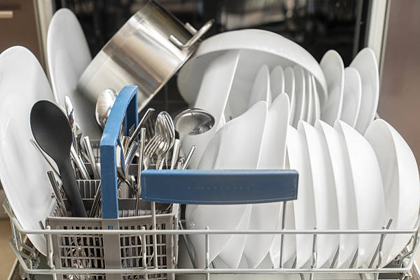 Open dishwasher with clean dishes in the kitchen. Dish washing machine. Washer in kitchen.
