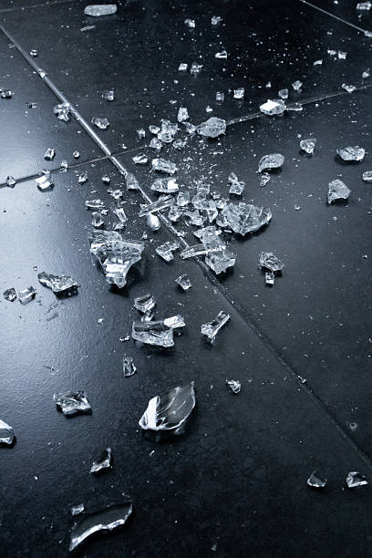 istock Broken glass shards on dark floor. Fragmented pieces and sharp edges 2231618083