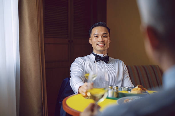 istock Young Asian Man in Formal Attire Smiling During Dinner with Wine 2231618223