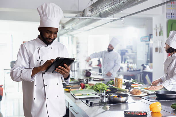 istock African american chef in a restaurant kitchen uses tablet to find new dish tips 2231623037