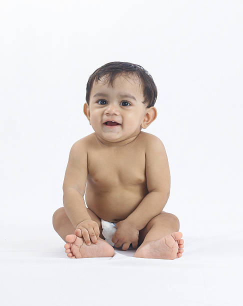istock Baby boy sitting in diaper with adorable curious expression. 2231623499