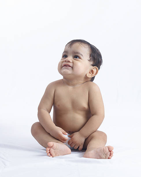 istock Baby boy sitting on floor looking up with wonder. 2231623503