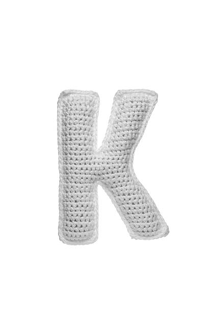 istock Handmade crocheted letter k in light grey yarn, isolated on white background, soft textured decoration or toy 2231626586