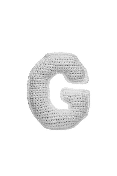 istock Handmade crocheted letter g in light grey yarn, isolated on white background, soft textured decoration or toy 2231626588