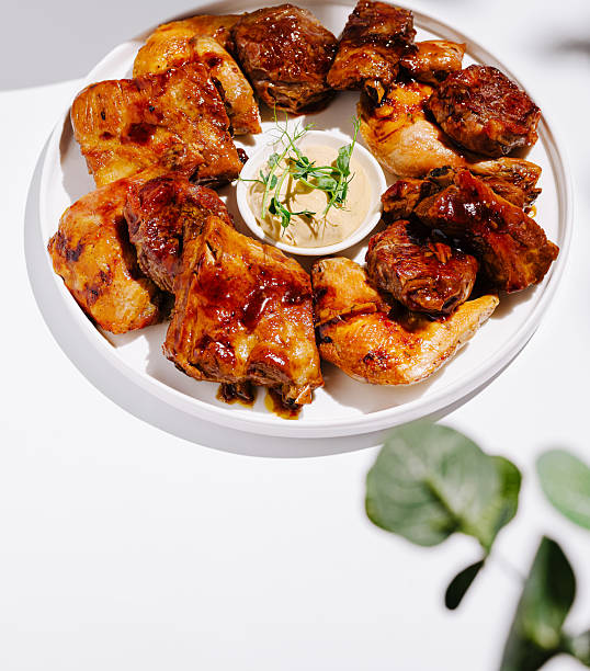 istock Grilled chicken platter served with dipping sauce on a white background 2231629029