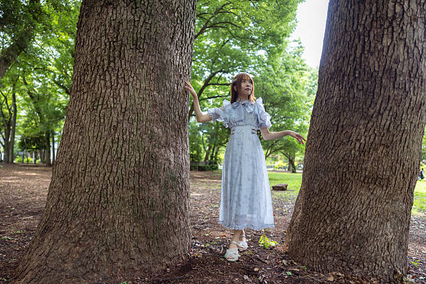 Young woman standing between trees in forest