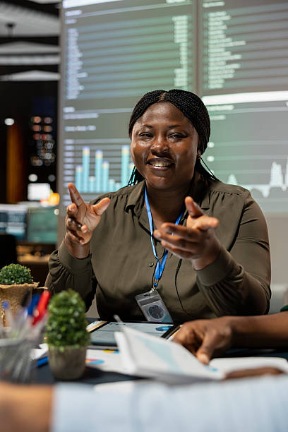 Smiling black administrator discuss budgeting with her team after hours