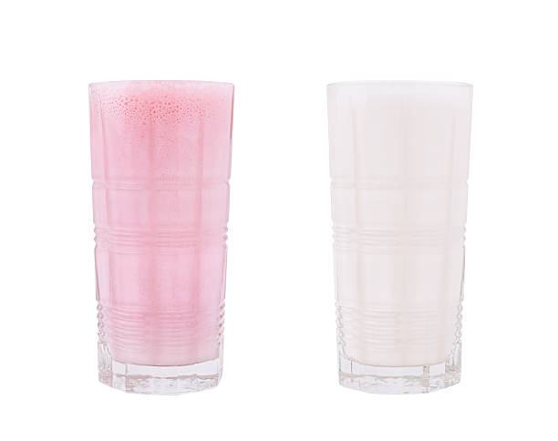 Two tall glasses filled with drinks, one pink and frothy, the other white and creamy, placed side by side on a clean surface, suggesting a refreshing treat for a warm day.