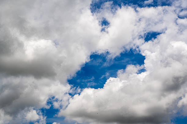 A stunning view of a vibrant blue sky adorned with fluffy white clouds. This image captures the beauty and tranquility of a bright day, inviting feelings of peace.