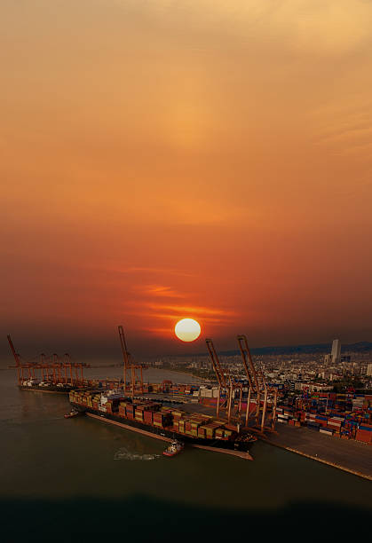 Aerial view of cargo container ship in transit at sunset.