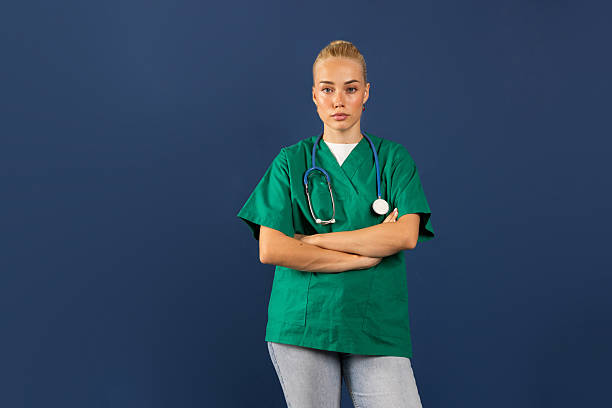 istock Confident young doctor posing with crossed arms on blue background 2231638005