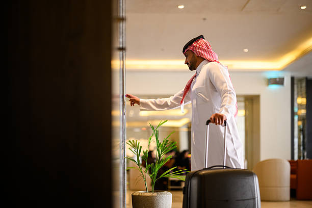 istock Side view of Arab businessman pressing elevator button inside illuminated hotel apartment lobby 2231641385