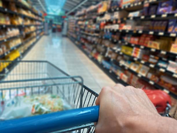 istock Anonymous Woman Pushing a Red Shopping Cart 2231641624