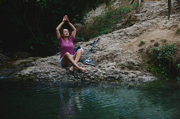 istock Woman Practicing Yoga Outdoors by a Stream in a Natural Setting 2231643222