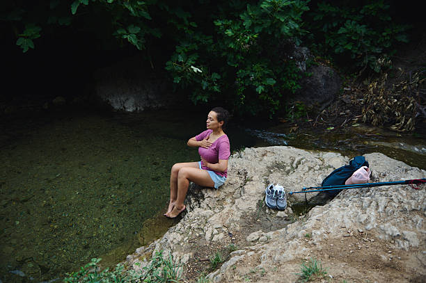 istock Woman Meditating by a Tranquil River in a Natural Setting 2231643269