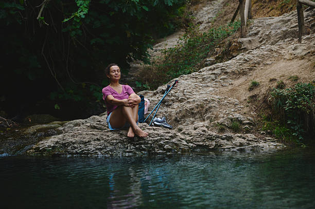 istock Serene Woman Relaxing by a Tranquil River in Nature 2231643336