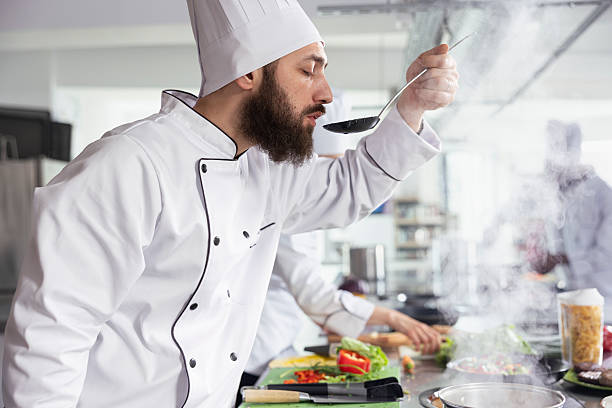istock Male head chef tastes a rich aromatic sauce and testing the flavors 2231644608