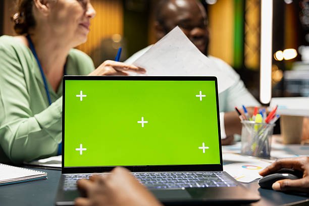 istock Company associates briefing after hours next to chroma key screen 2231648395