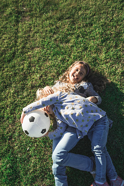 istock little sister having fun on the grass 2231650057