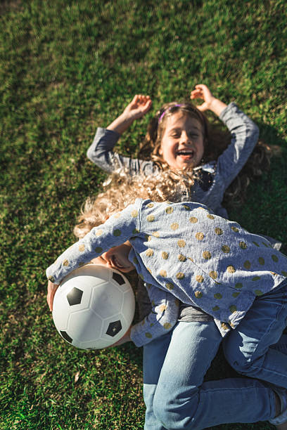 istock little sister having fun on the grass 2231650111