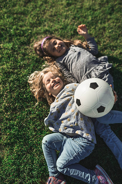 istock little sister having fun on the grass 2231650143