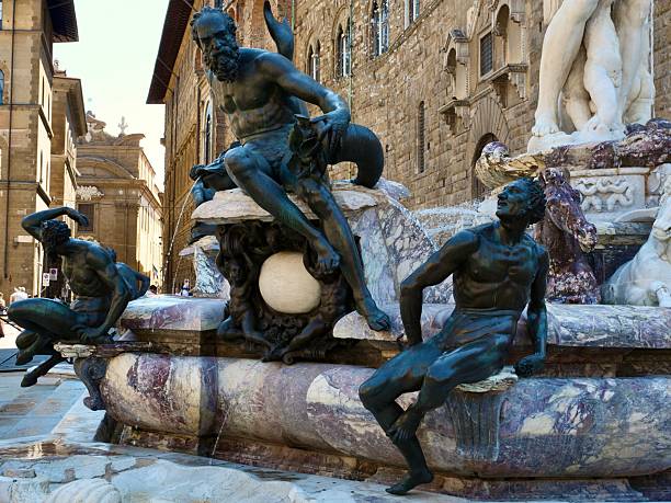 Close-up view of the Fountain of Neptune in Piazza della Signoria, Florence, Italy. Renaissance marble and bronze sculptures with water splashing in front of Palazzo Vecchio.