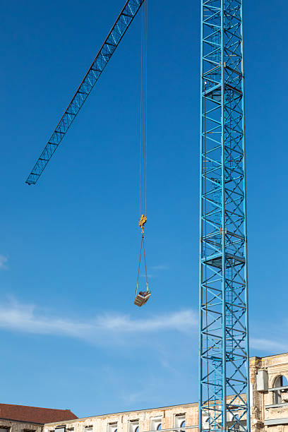 istock Construction crane with cable and pulleys lowering a load of construction material for building restoration, Budapest Hungary. 2231650715
