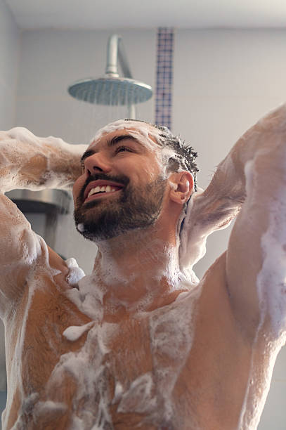 istock Young muscular smiling man taking a shower 2231653606