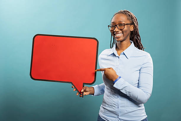 istock Joyful woman points red cardboard sign 2231653926