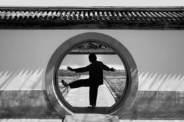 China Beijing, public park, older woman doing Tai Chi exercises