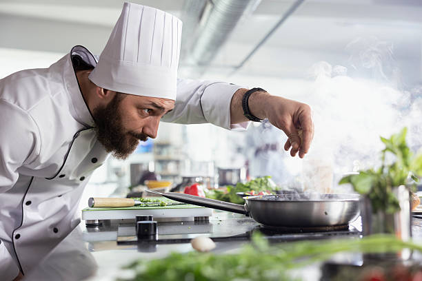 istock Chef adding the finishing touches to a plated dish with fresh herbs 2231655430