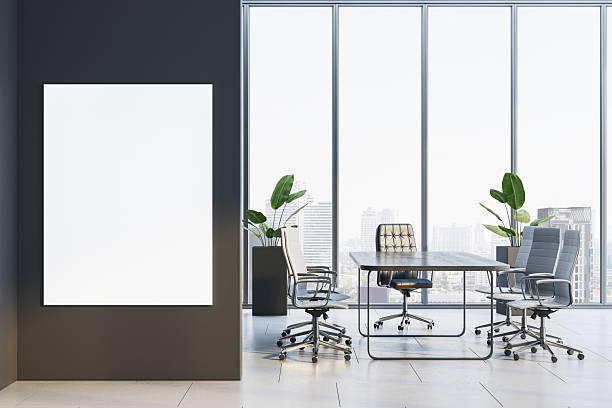 istock Modern conference room interior with blank vertical poster frame on dark wall and sleek office furniture near large windows with city view. 3D Rendering 2231657841