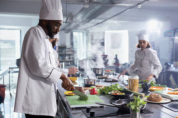 istock Focused professional chef minced fresh herbs for a new gourmet meal 2231658364