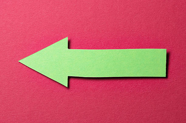 istock Green cut out blank paper cardboard arrow direction sign with copy space for text on red background, flat lay top view pointing symbol conceptual message backdrop 2231658676