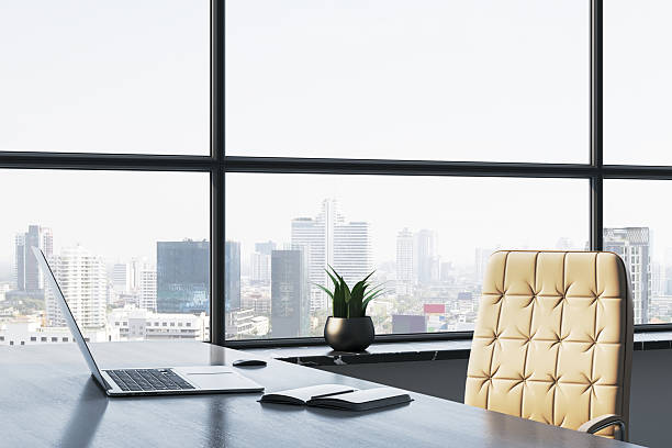 istock Modern office workspace with leather chair, laptop, notebook, and large city view window in a high-rise corporate building interior. 3D Rendering 2231659401