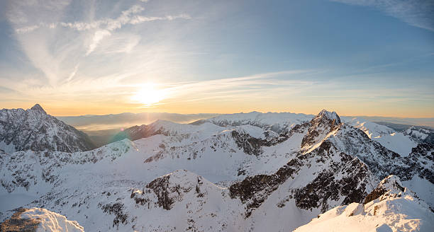 Mountain panorama in the light of the setting sun. Snow-covered rocky peaks in the background. Tatra Mountains, Poland, Europe.