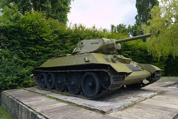 istock Historic tank displayed in a memorial park surrounded by greenery under a clear sky 2231661884
