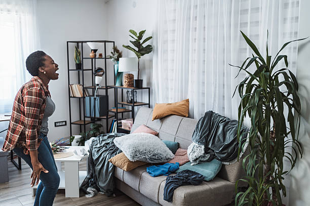 Frustrated woman screaming at messy apartment living room