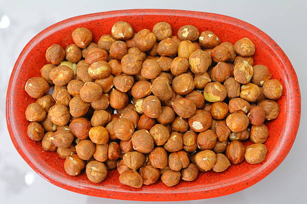 istock Hazelnuts in a red bowl on a white background, top view 2231666596