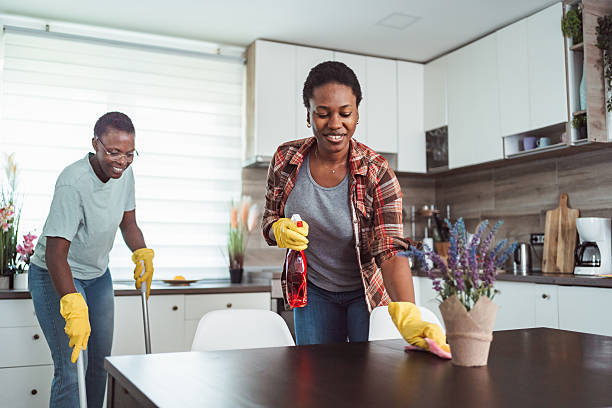 istock Two cheerful black women cleaning the kitchen table and floor 2231666630